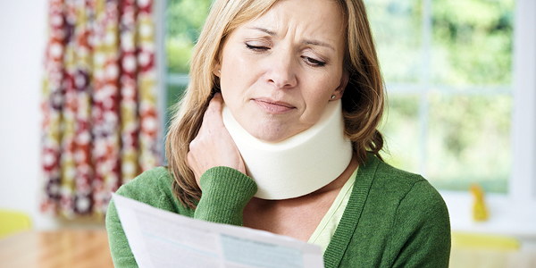 A person recovering from a neck injury reviewing paperwork